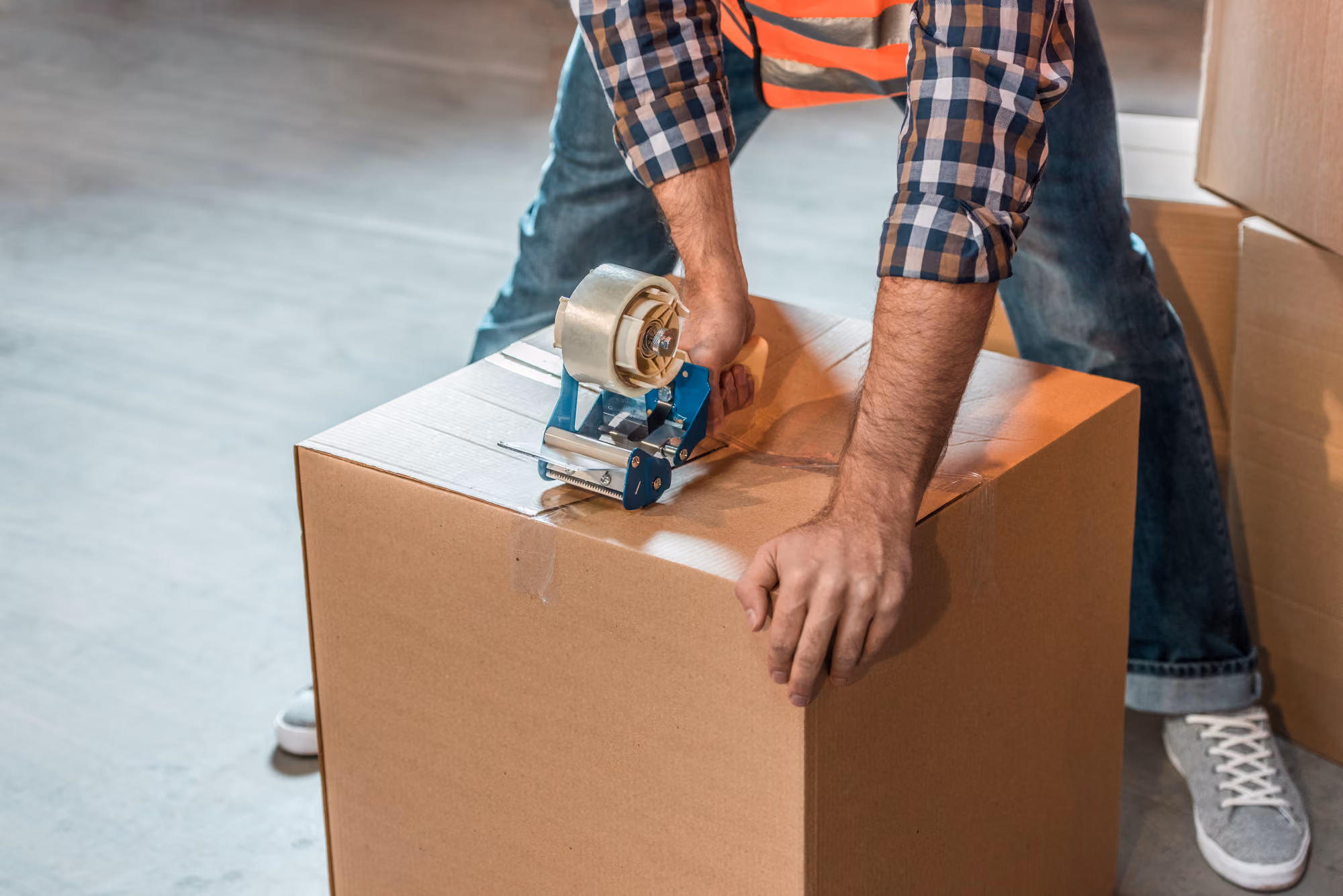 A logistics worker tapes a box for delivery