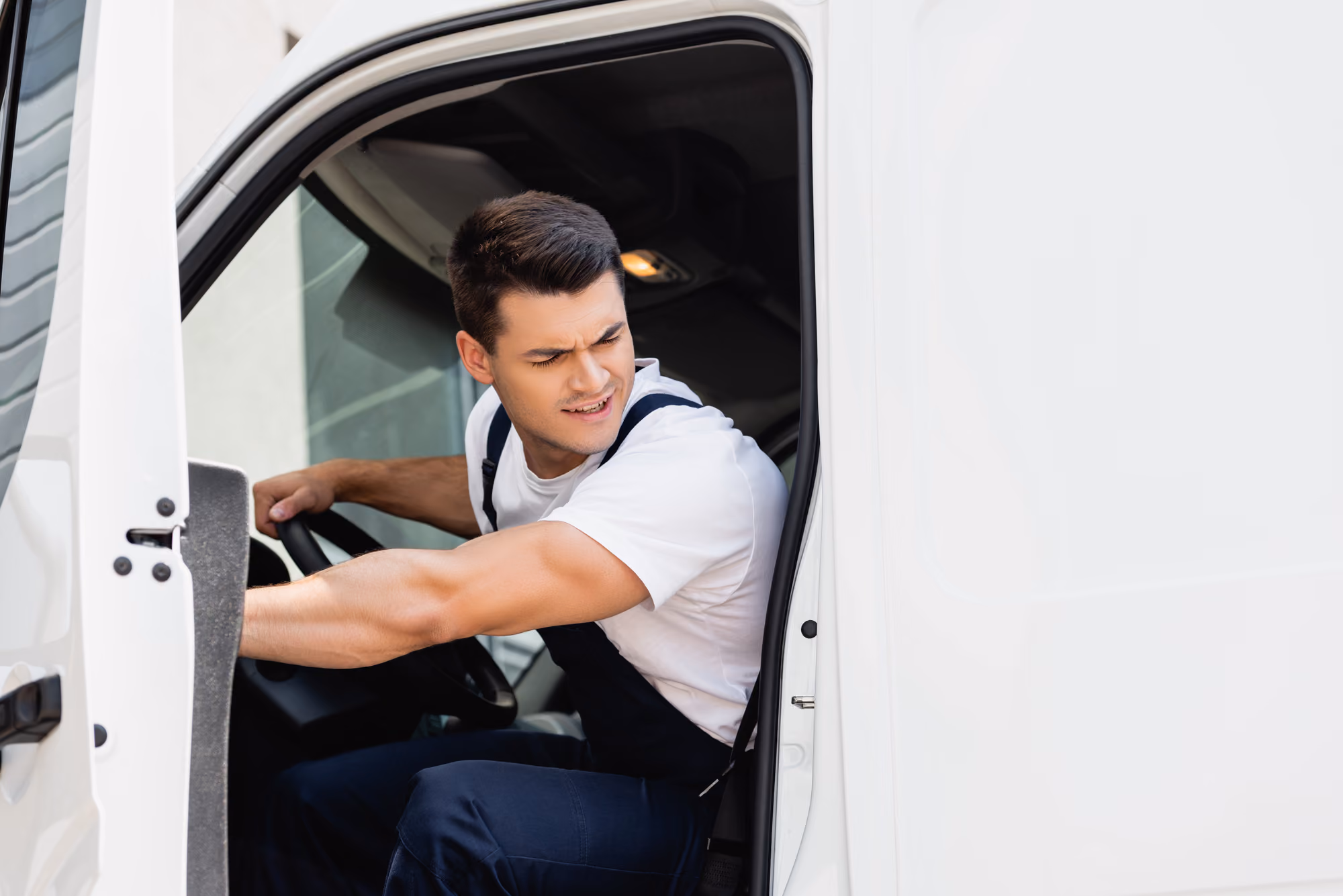 A man leans out of the driver side of a truck