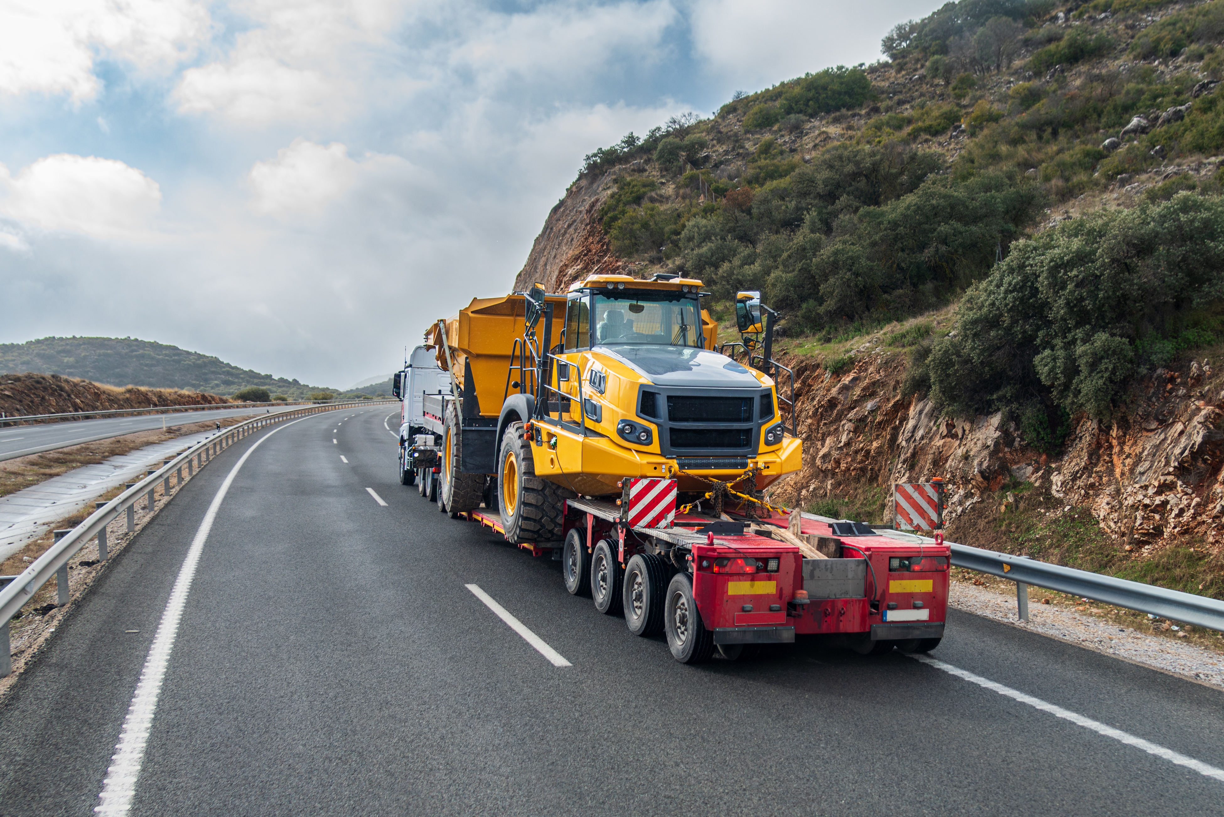 Um camião de plataforma transporta máquinas de construção