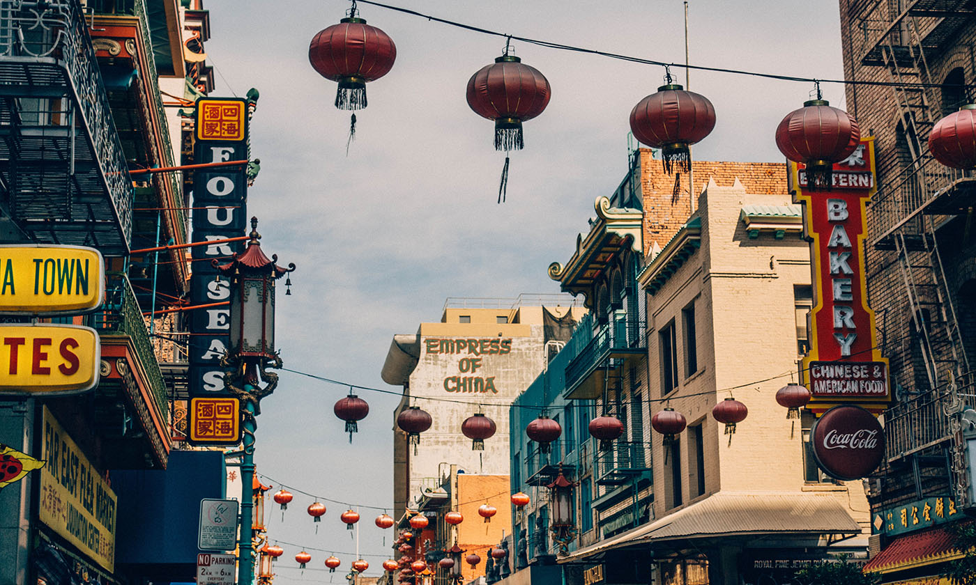 San Francisco Chinatown street scene with hanging red lanterns, vintage signs, and the Empress of China building