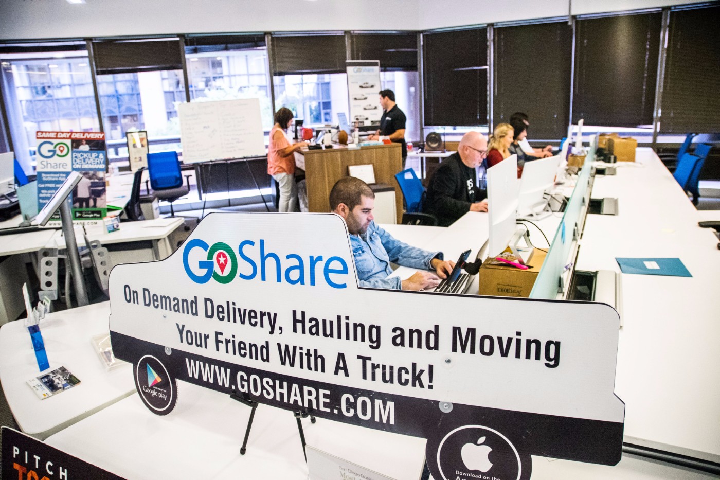 GoShare office workspace with truck-shaped promotional sign reading On Demand Delivery, Hauling and Moving