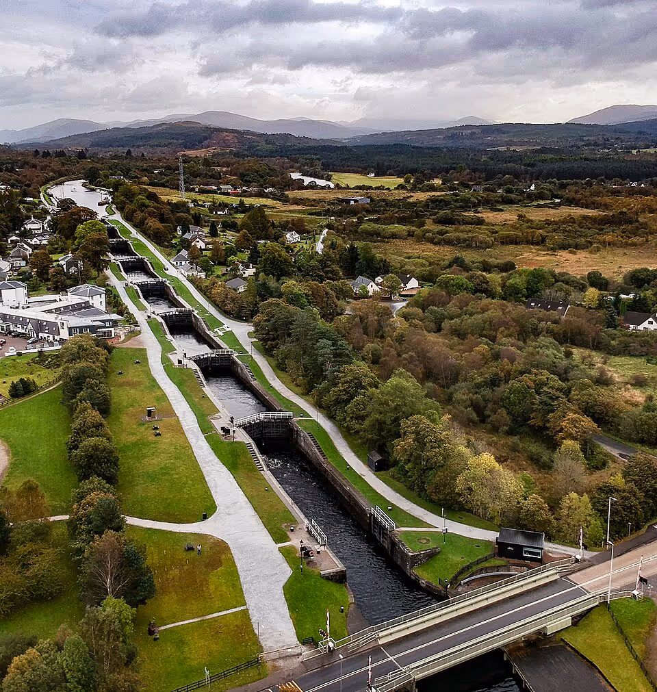 Aerial view of a series of canal locks with pathways and greenery on both sides.