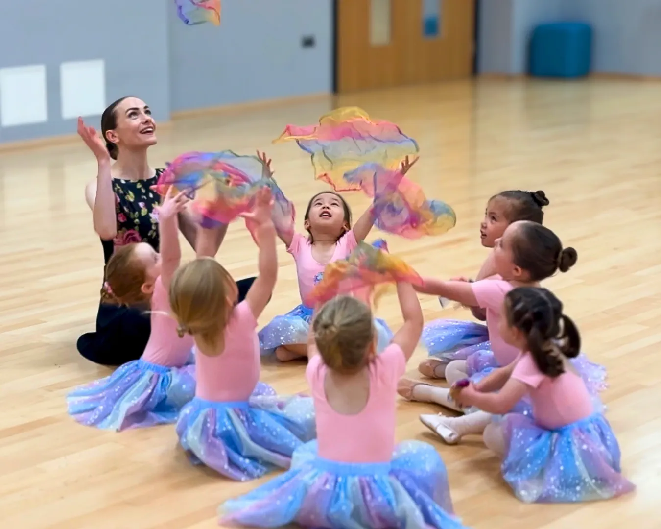 Fairytale Ballet® Ballerinas throwing rainbow scarves in the air and catching them.