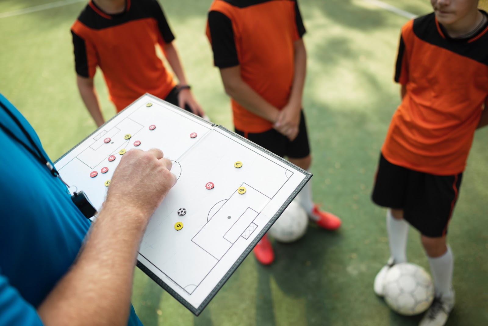 coach defining the vision of youth soccer team in field