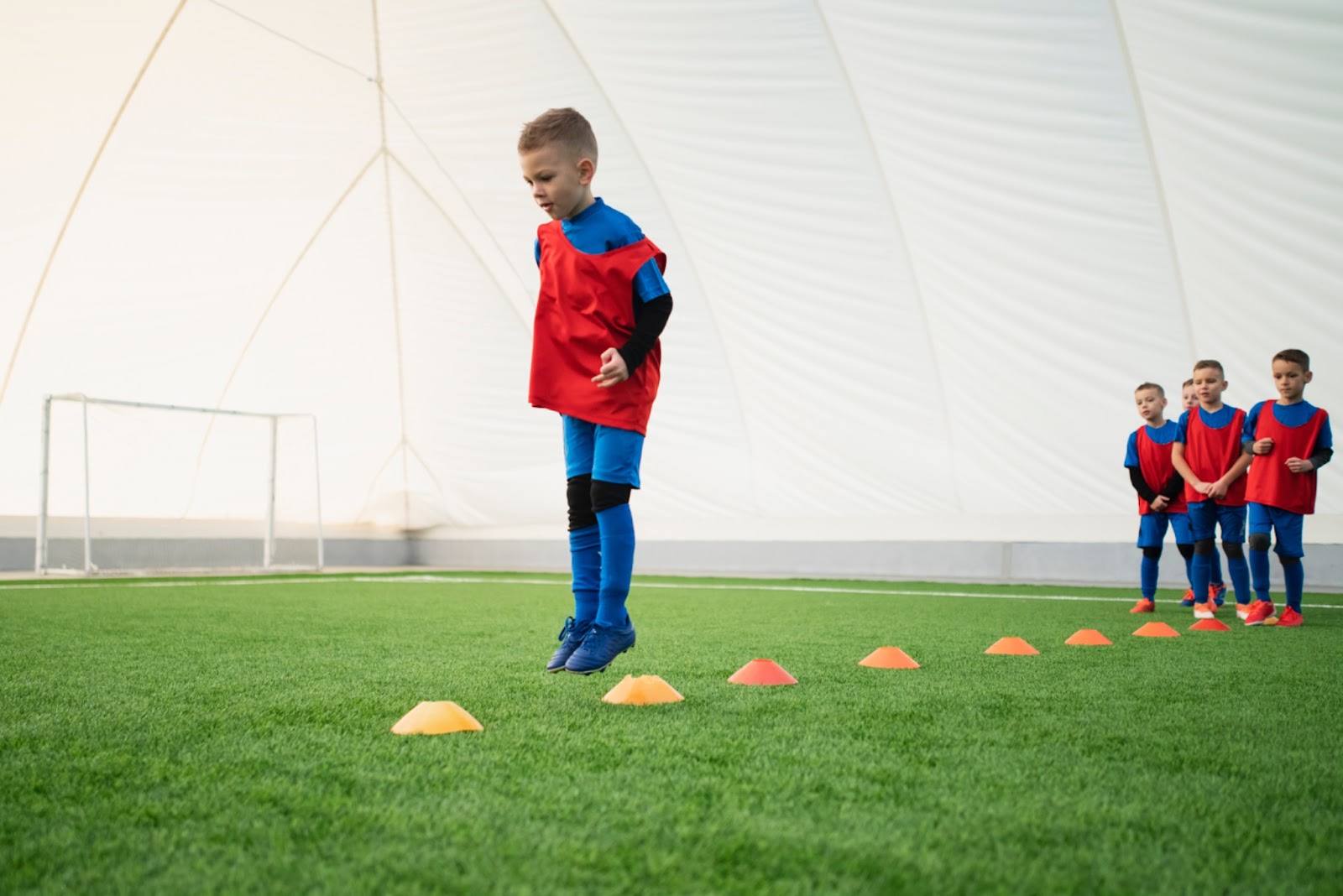 Kids practicing dribbling drill in soccer academy