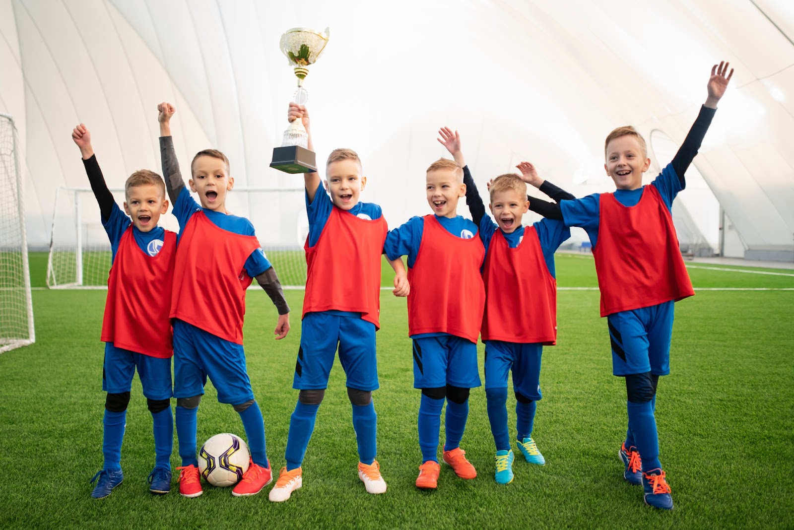 kids at soccer academy holding winning trophy of a tournament