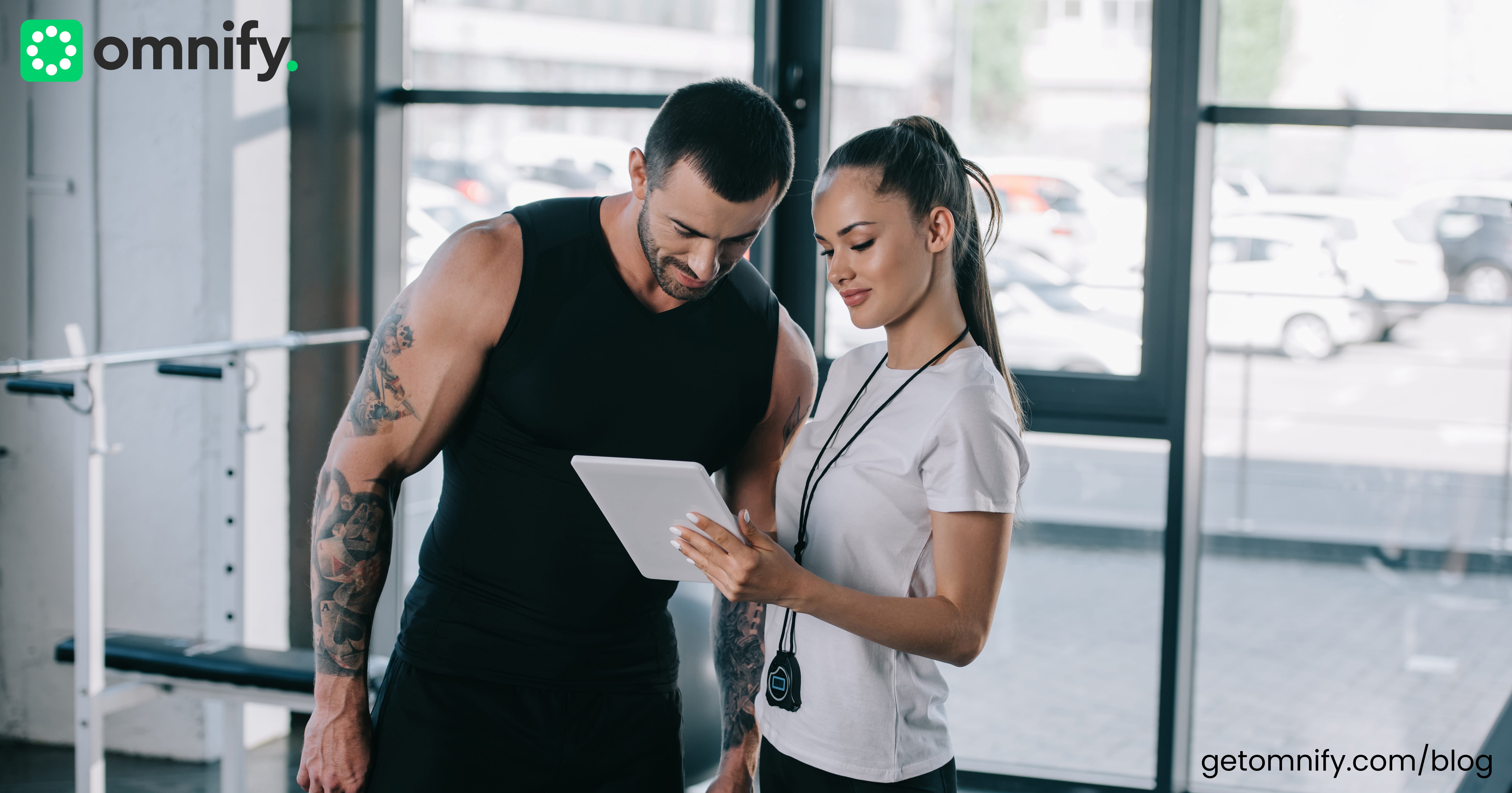 A fitness trainer helping a trainee at the gym