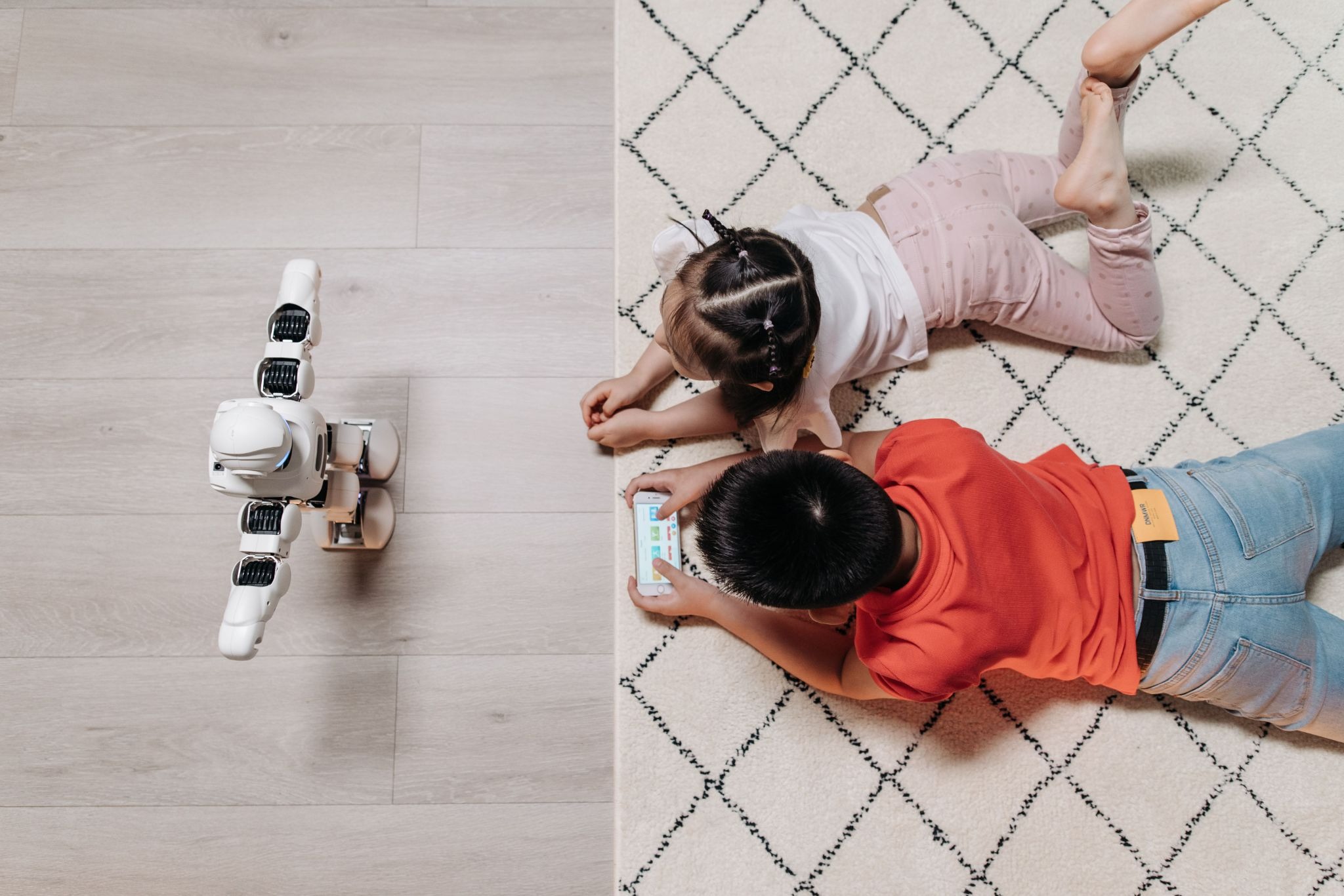 https://www.pexels.com/photo/kids-lying-on-the-carpet-in-front-of-a-robot-8295060/ 