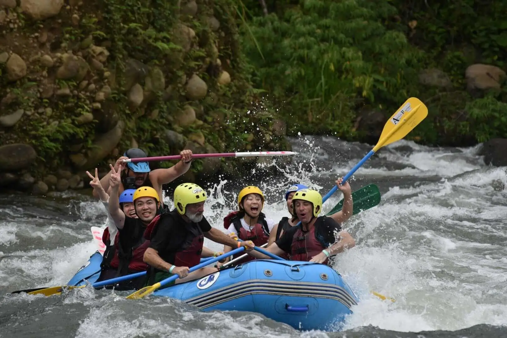 Group of adventurers enjoying Class III-IV whitewater rafting on Sarapiquí River near Arenal, Costa Rica.