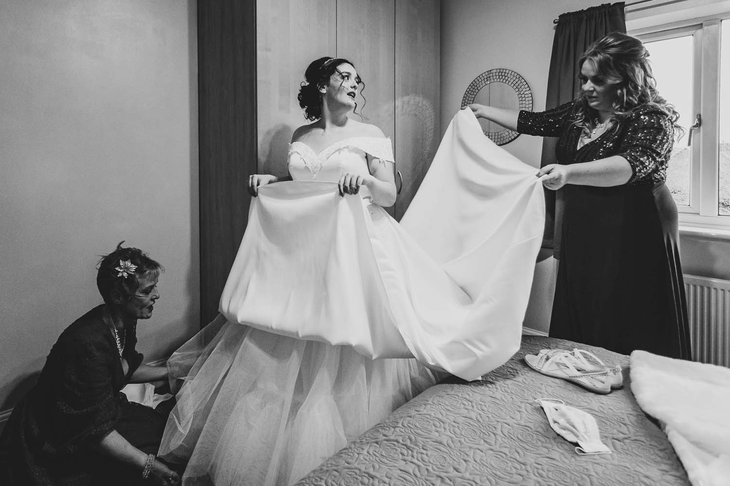 A bride with her Mother and bridesmaid getting ready or the cermony.