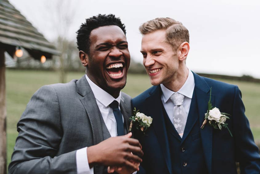 A Groom and his Best Man laughing and sharing a joke.