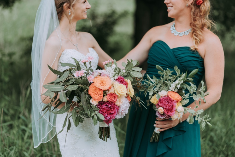 Bride and her Maid of honour holding hands dressed ready for the ceremony.