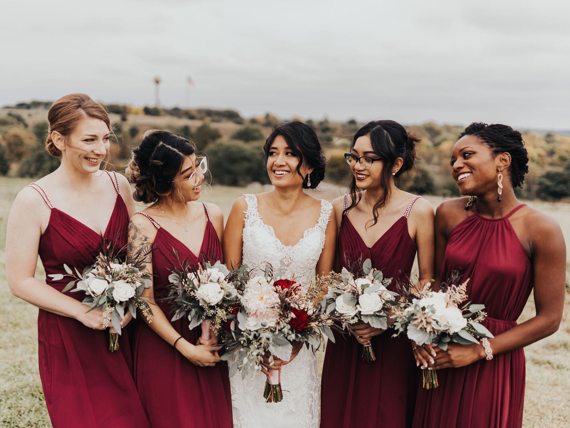 Bride in her ivory wedding dress with 4 bridesmaids in burgundy red.