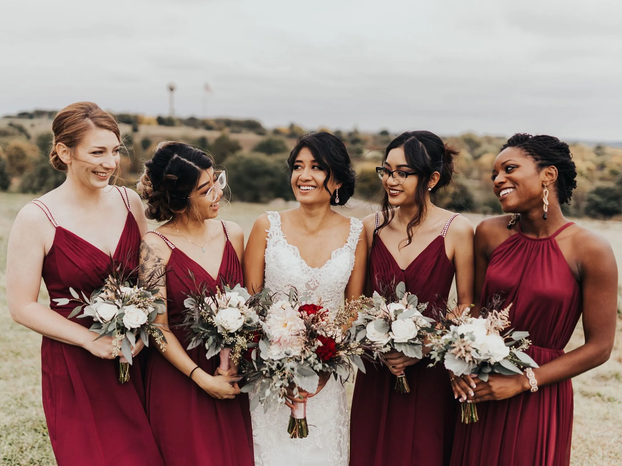 Bride in her ivory wedding dress with 4 bridesmaids in burgundy red.