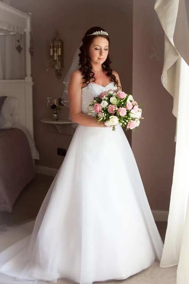 Bride wearing a white Aline gown with beaded sweetheart bodice and soft tulle skirt.