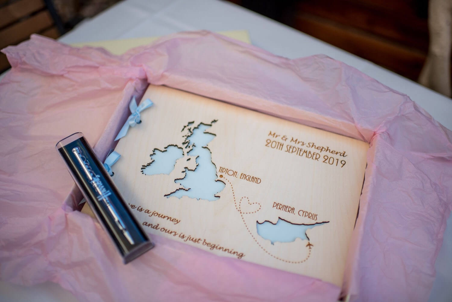 A wooden wedding guest book depicting the UK and Cyprus there the couple got married.