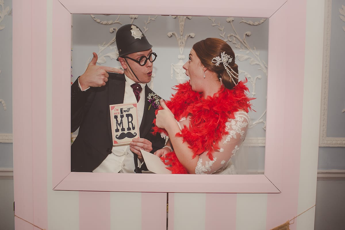 Bride and Groom in a photo booth dresses in fancy dress.