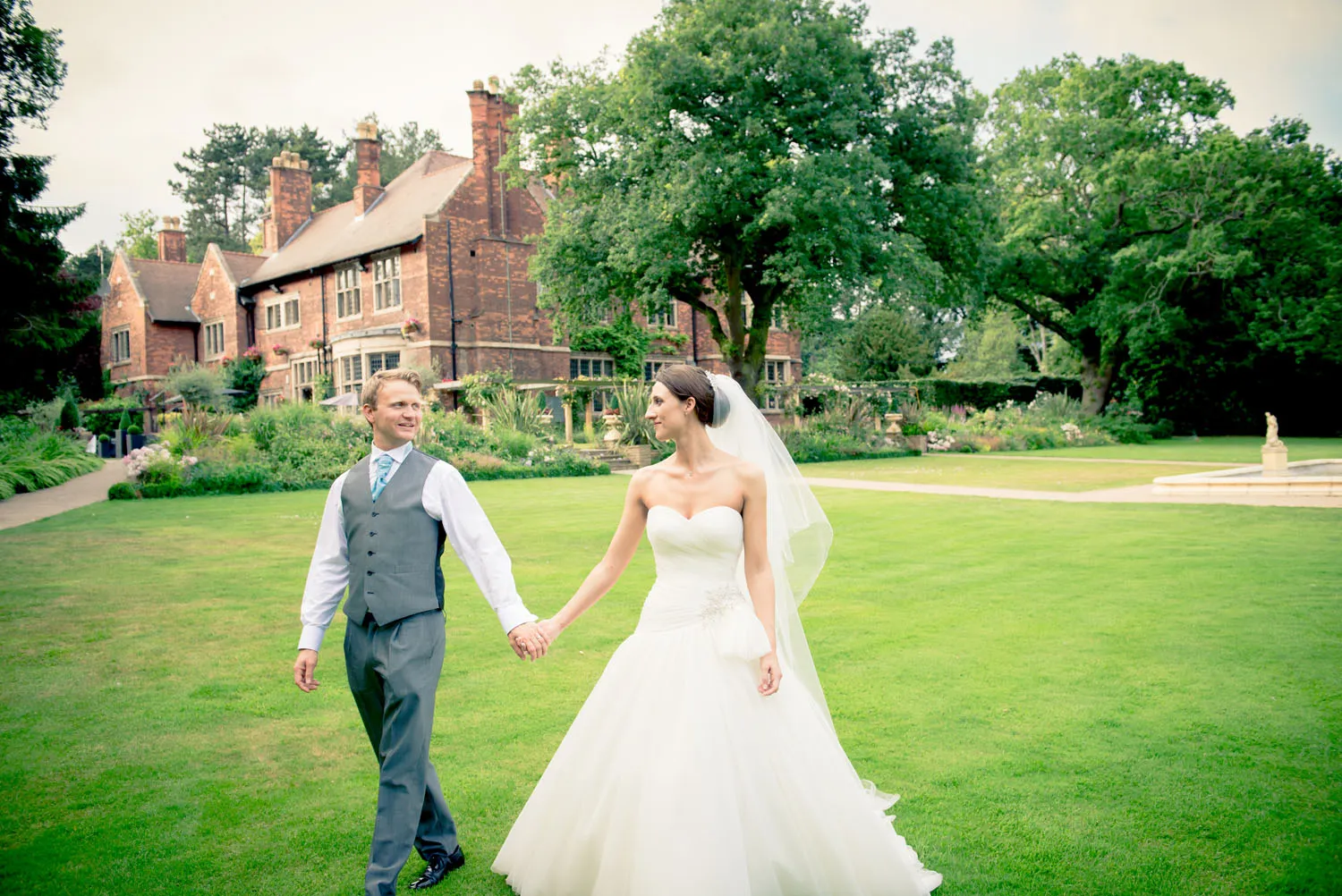 Bride and Groom waling together in the grounds of a hotel.