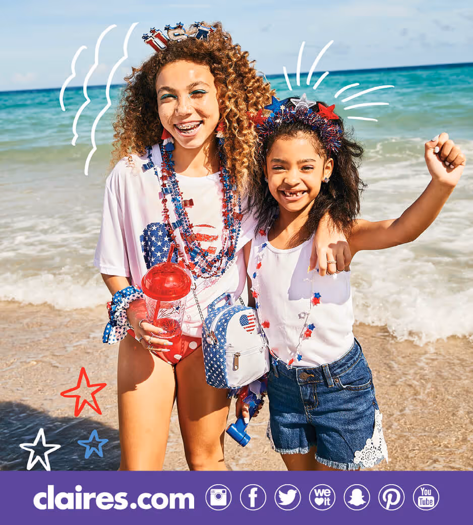 Two girls wearing red, white, and blue Claire's accessories on the beach