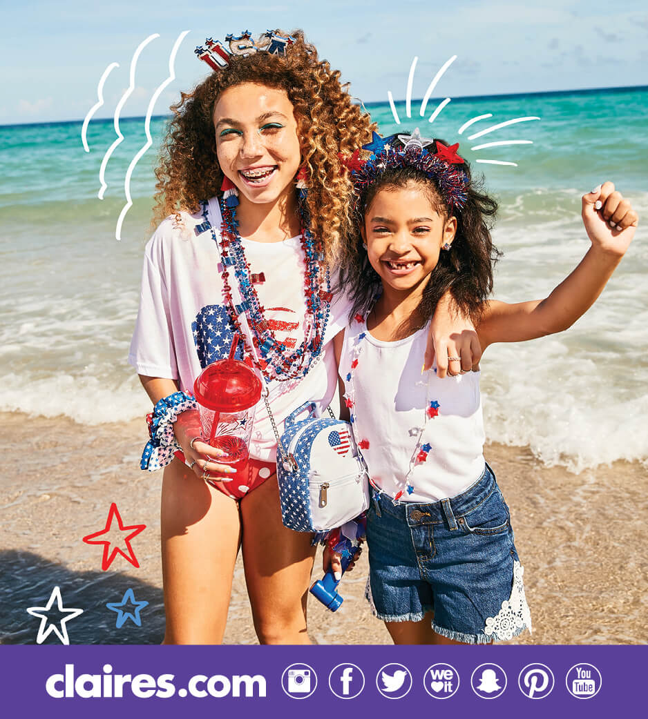 Two girls wearing red, white, and blue Claire's accessories on the beach