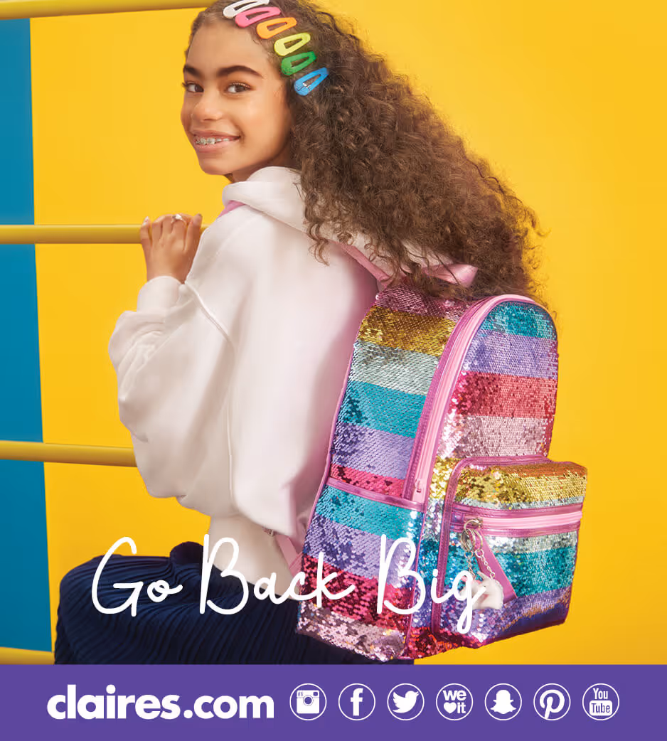 Girl wearing rainbow hair clips and a sequined rainbow backpack