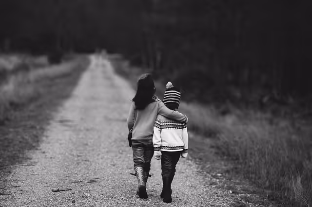 two kids walking on a dirt road