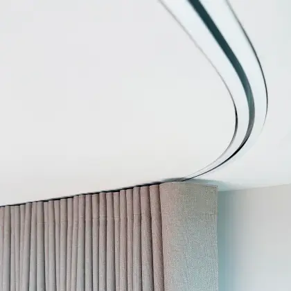 Modern building entrance with large glass windows showing interior seating and a person inside.