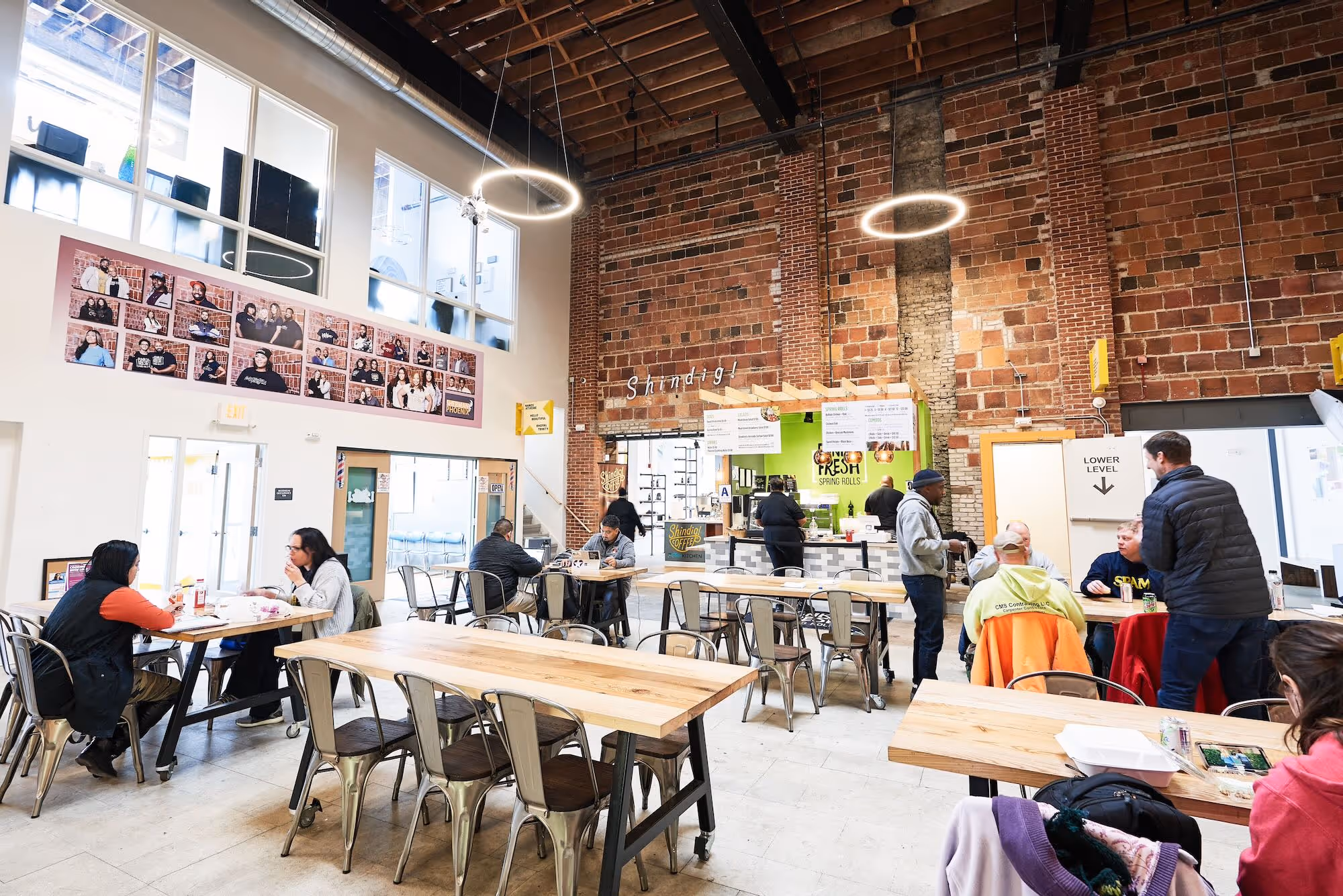 Customers are eating and interacting with each other and with vendors in a colorful indoor dining area.