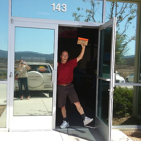 Image of owner in front of office doors with reflective window film applied.