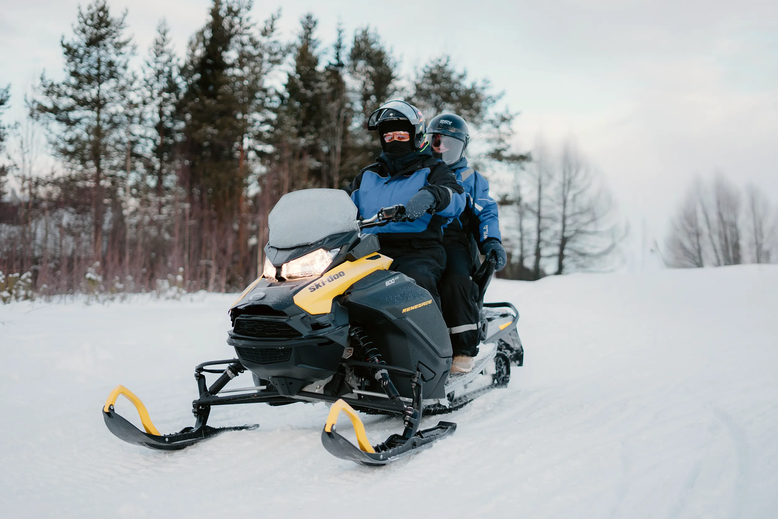 Kaksi ihmistä moottorikeilemassa Enonveneen Ski-Doo kelkalla