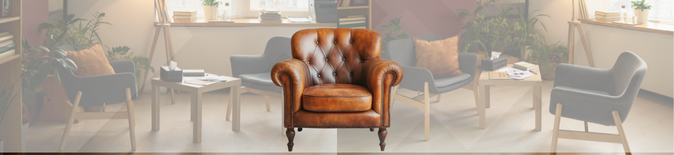 Poltrona de couro marrom estilo Chesterfield em destaque, numa sala clara com poltronas cinza, mesinhas e plantas