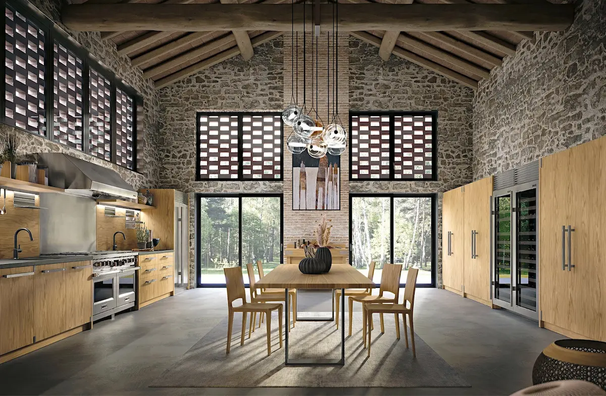 Grande image, d'un séjour avec table et chaises en bois et d'un côté la cuisine toute équipée en bois et de l'autre des rangements et cave à vin