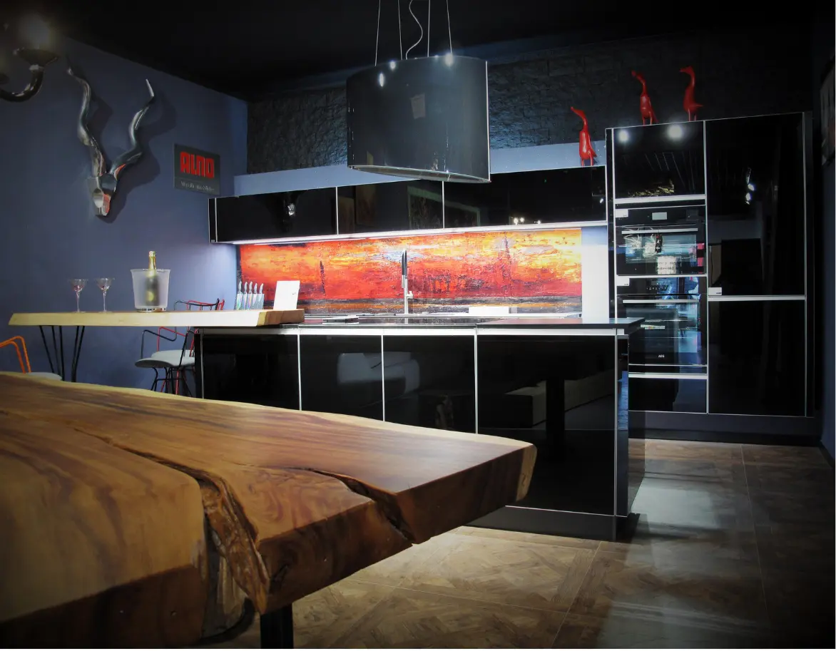 Cuisine sur mesure avec table en bois massif, et ilot central et cuisine en noir brillant et décoration du mur de la cuisine en peinture