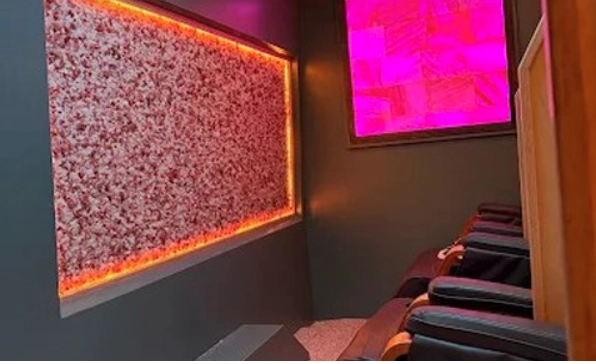 Inside the Mobile Saltworks van: a lit Himalayan salt wall, a pink chromotherapy panel and massage chairs