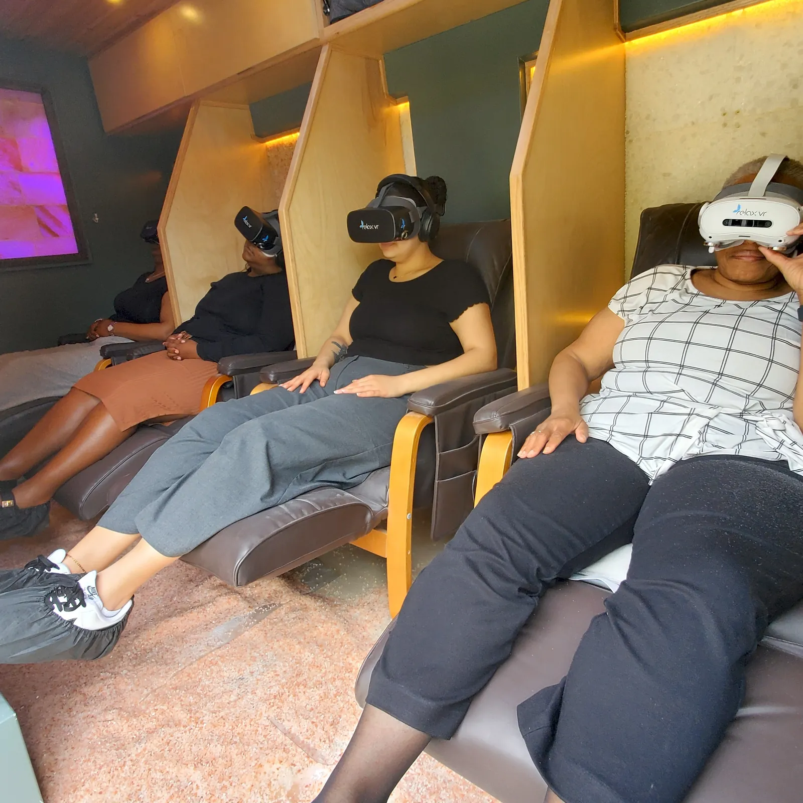 A van full of clients reclining in massage chairs with Relax VR headsets in the Mobile Saltworks salt cave