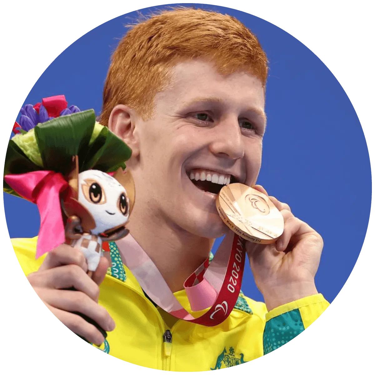 Boy biting a gold medal he won at the Paralympics