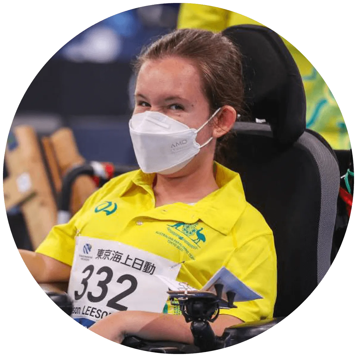 Smiling girl in wheelchair with facemask and in Australian Paralympics uniform