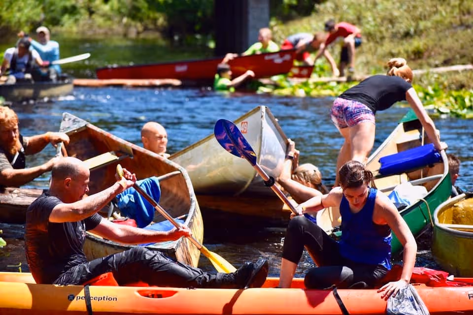 Several groups of canoe race participants get piled up near the finish line.