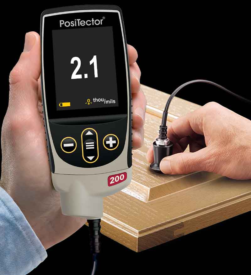 PosiTector 200 measuring coating thickness on a cupboard door