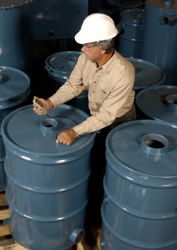 Photo of a man measuring paint thickness on metal drums with a PosiTector 6000