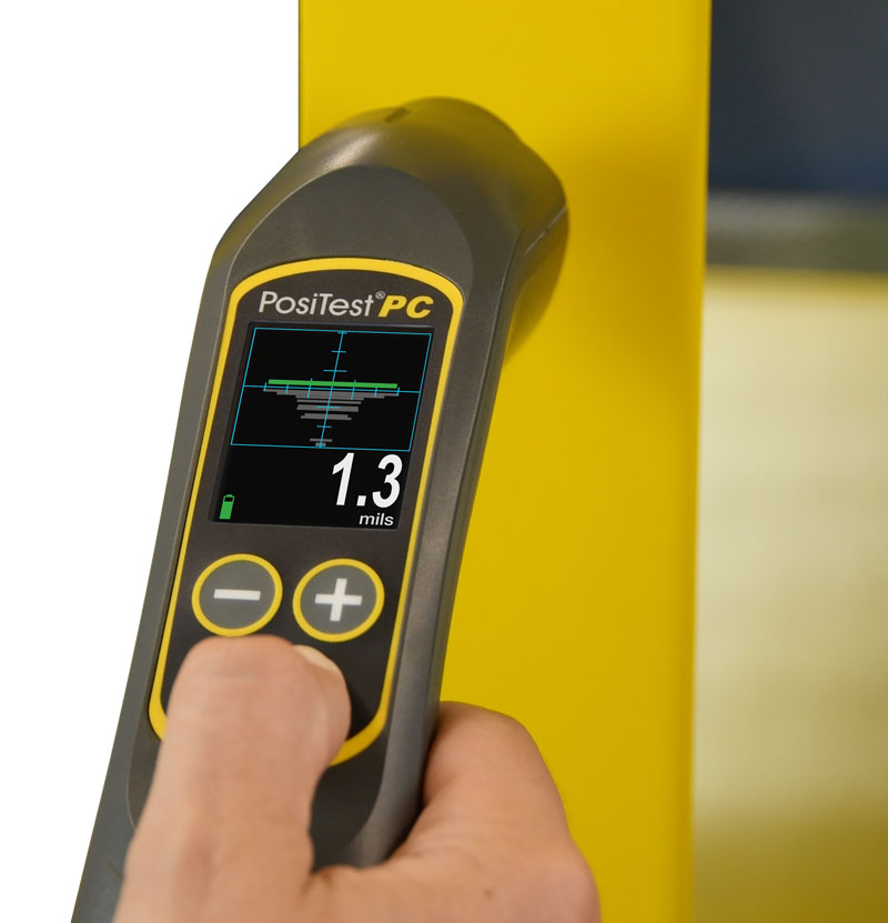 Photo of the PosiTest PC measuring uncured powder coating thickness on a yellow-coated part