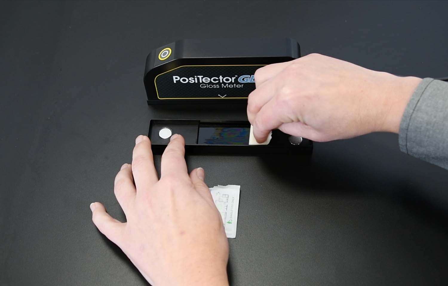 이미지에서 PosiTector GLS 캘리브레이션 타일을 청소하는 방법을 보여줍니다.