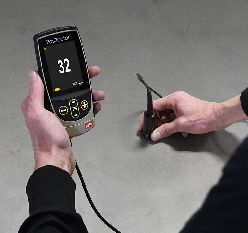 Photo d'un PosiTector SPG TS mesurant le profil de la surface d'une dalle de béton
