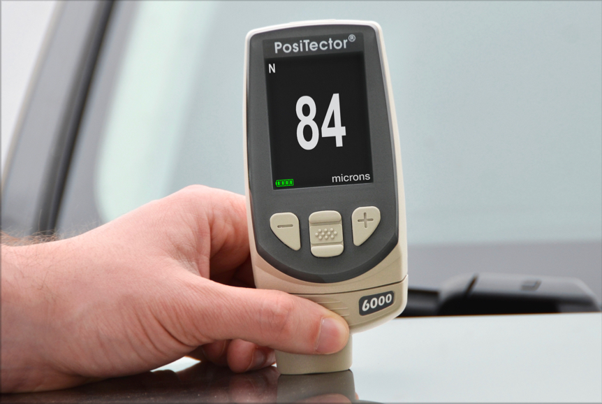 PosiTector 6000 在有色金属模式下测量汽车引擎盖油漆厚度的特写照片