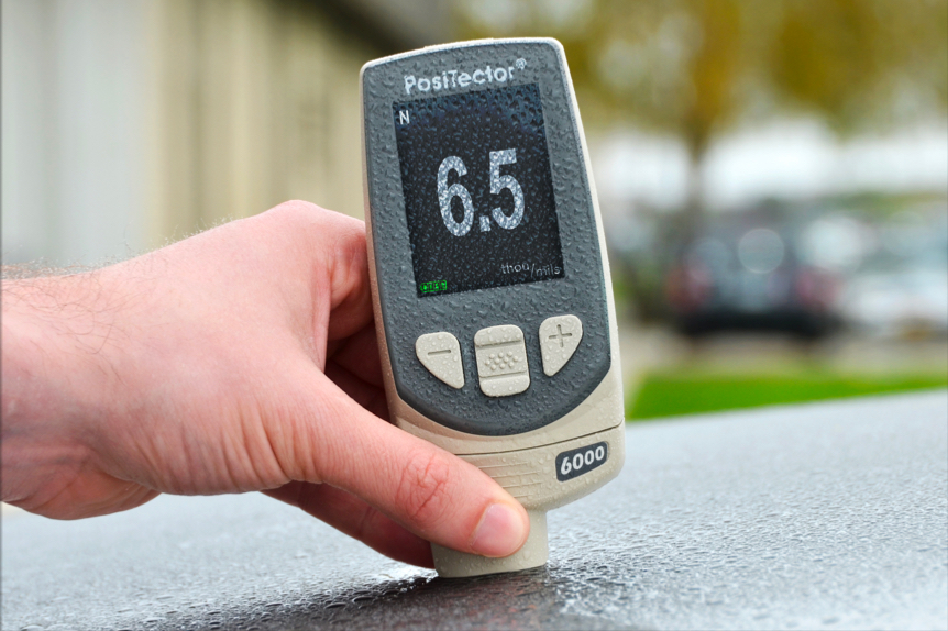 PosiTector 6000 密耳测量仪测量汽车引擎盖油漆厚度的特写照片