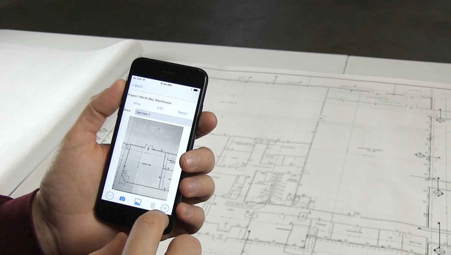 Photo of the PosiTector App being used to select RH test locations against blueprints. Caption—Use the PosiTector App to map and overlay test locations.