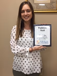 Kaeley Jones, Marketing Director at Paddock Mall holding a thank you plaque