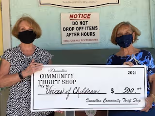 Georgi Gunnell of the Dunnellon Community Thrift Shop presents a check to Sue Carpenter of Voices for Children.