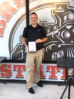 Chris Morra of Breakfast Station #7 in Beverly Hills holding a thank you plaque from Voices for Children