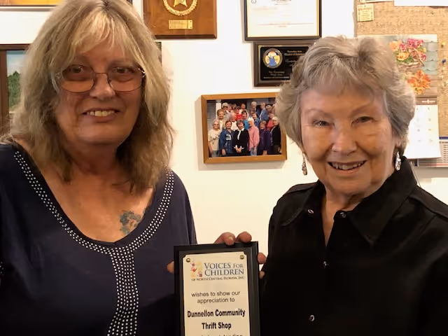 Barbara Morris and Joann McCullough of Dunnellon Community Thrift Shop accepting a Thank You Plaque from Voices for Children